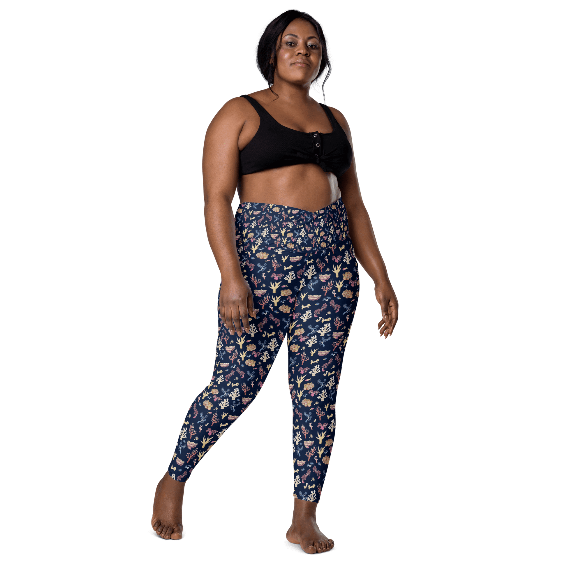 Woman wearing navy blue leggings with a colorful coral and sea life pattern