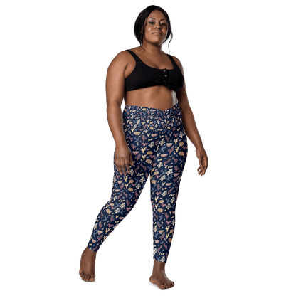 Woman wearing navy blue leggings with a colorful coral and sea life pattern