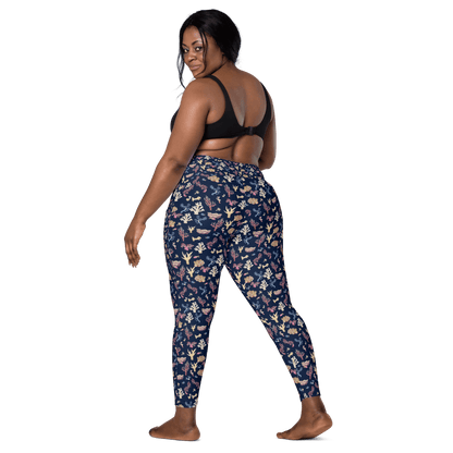Woman wearing navy blue leggings with a colorful coral and sea life pattern