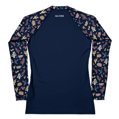Back of All You Can Sea navy blue rashguard with a colorful coral and sea life pattern and the name of the brand visible on the top