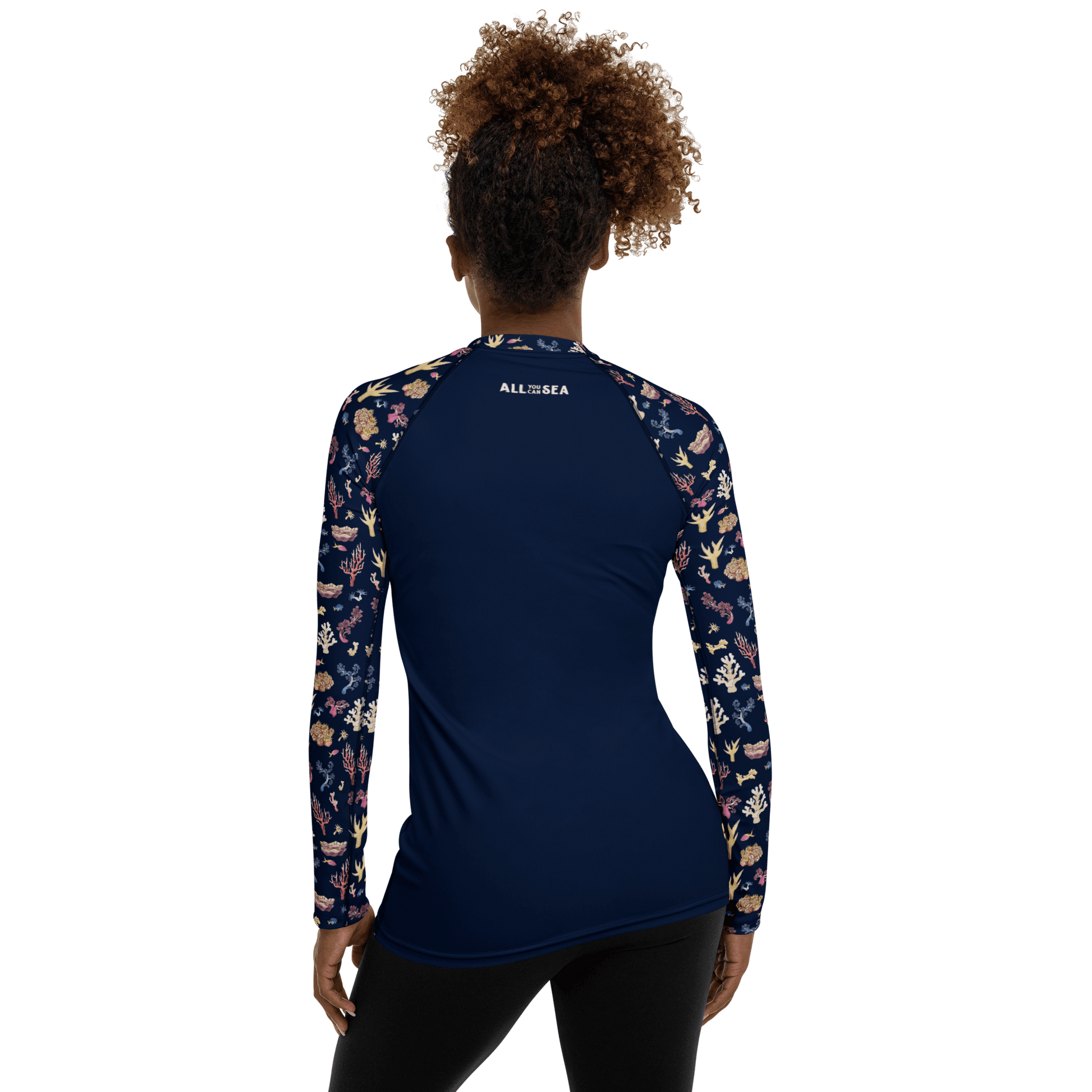 Woman wearing All You Can Sea navy blue rashguard with a colorful coral and sea life pattern