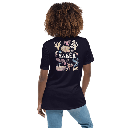 Person wearing a navy blue t-shirt with a colourful coral reef design and All You Can Sea text on the back